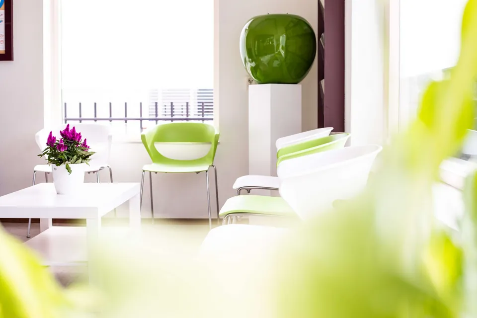 De wachtkamer van Tandartspraktijk Stiphout met frisgroene stoelen